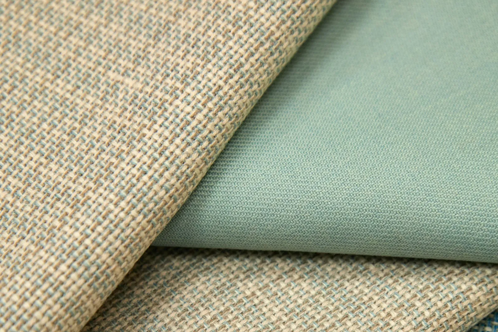 Curtain fabric samples laid out on a table for comparison.