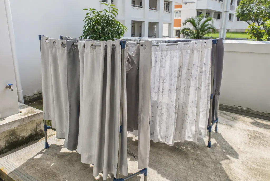 Curtains drying on a rack in a service yard.
