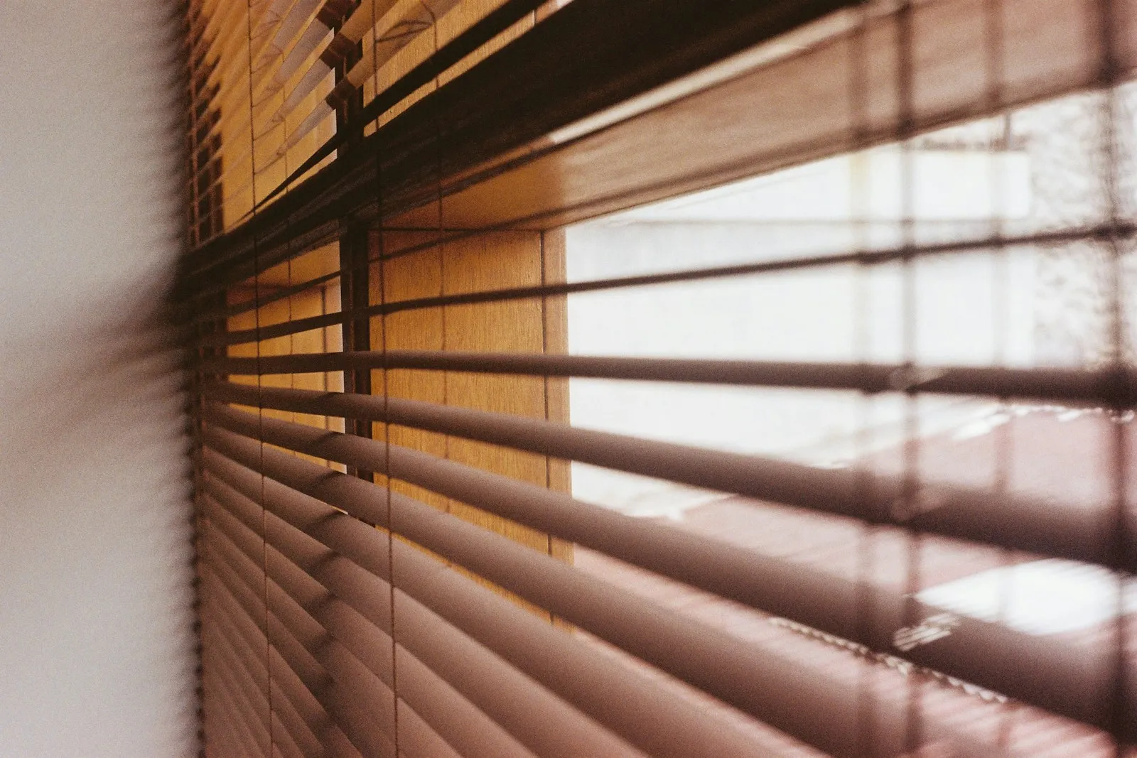 Wooden venetian blinds with sunlight coming through the slats.
